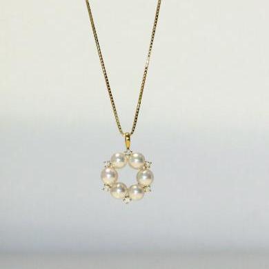 The 18ct yellow gold pearl and diamond circle pendant.